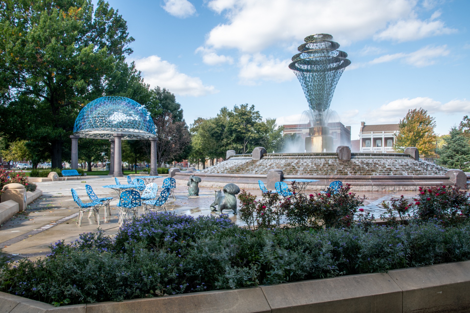 Bayliss Park fountain, surrounded by tables and chairs and squirrel statues.