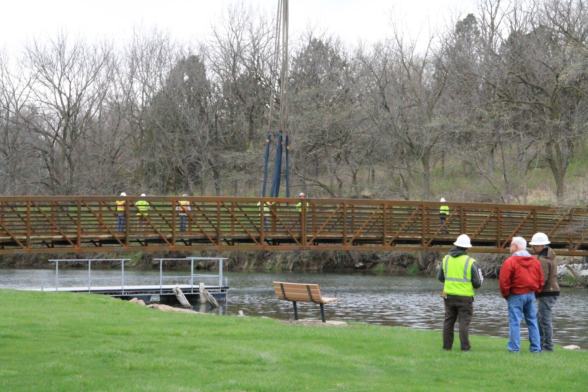 Pottawattamie County staff observe as crew members as they detach the crane from the bridge.