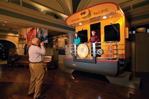Two children posing for a photo on a train caboose at the Union Pacific Railroad Museum in Council Bluffs, Iowa