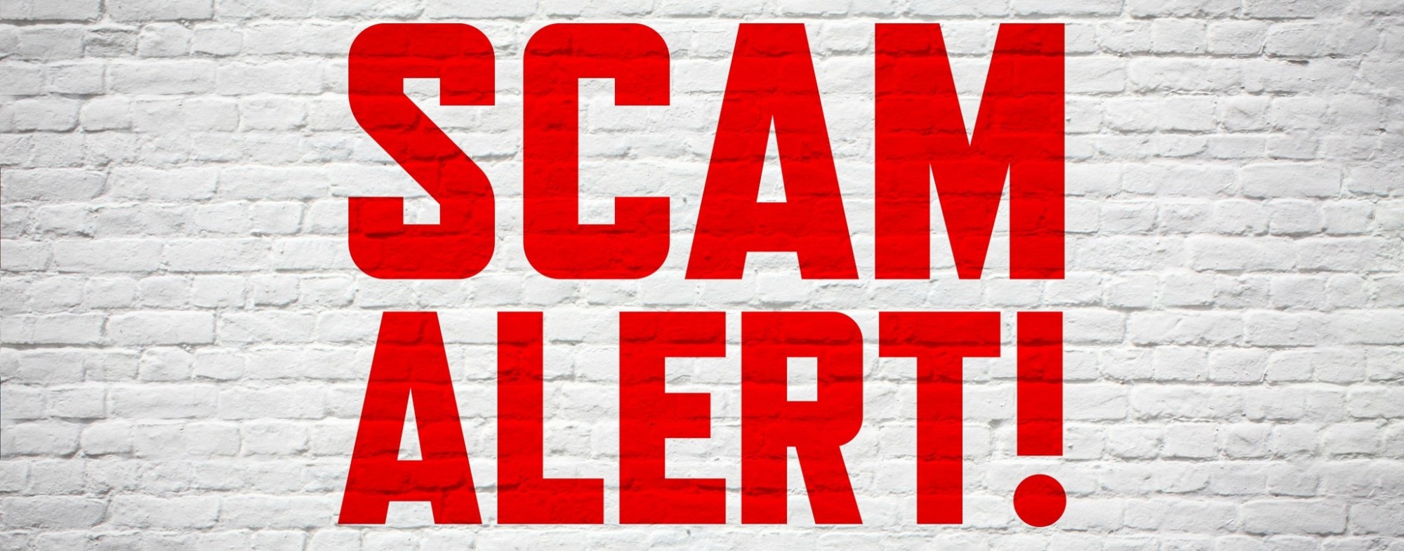 Scam Alert Red Text on White Brick Background