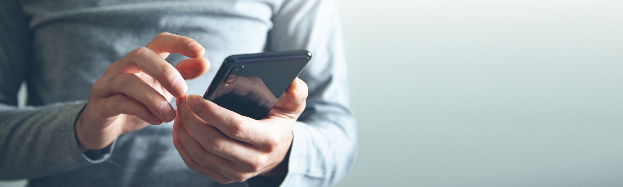 Close-up hands holding a cell phone
