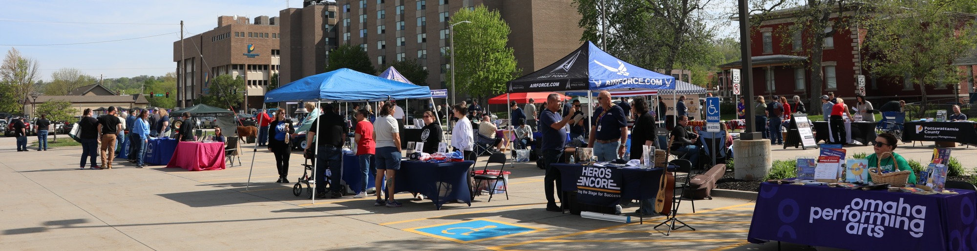 Attendees at Veterans Resource Festival visit vendor booths outside
